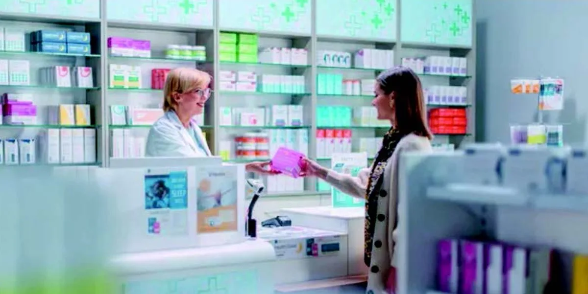 Woman collecting prescription from pharmacy