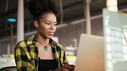 Woman wearing black and white checkered using laptop