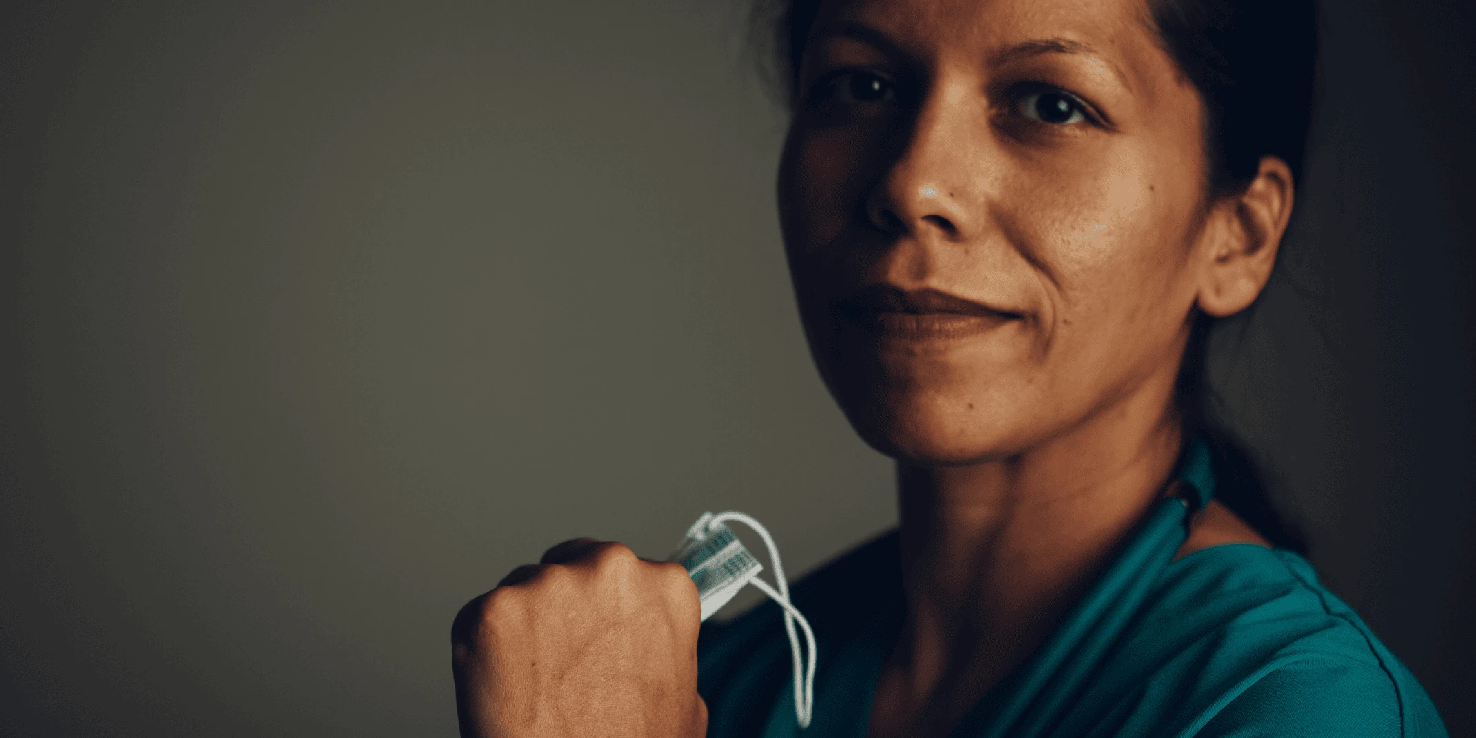 This is a photograph of a nurse holding a mask