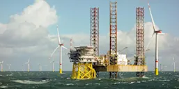 Image of Oil Rig surrounded with windmill