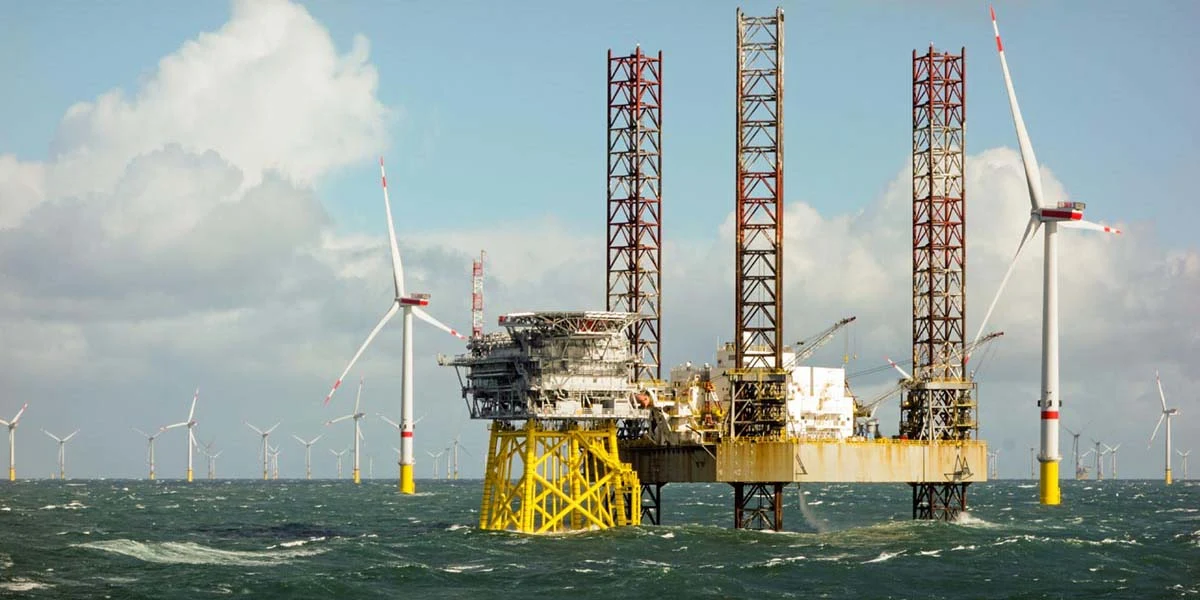 Image of Oil Rig surrounded with windmill