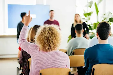 Woman raising hand during presentation