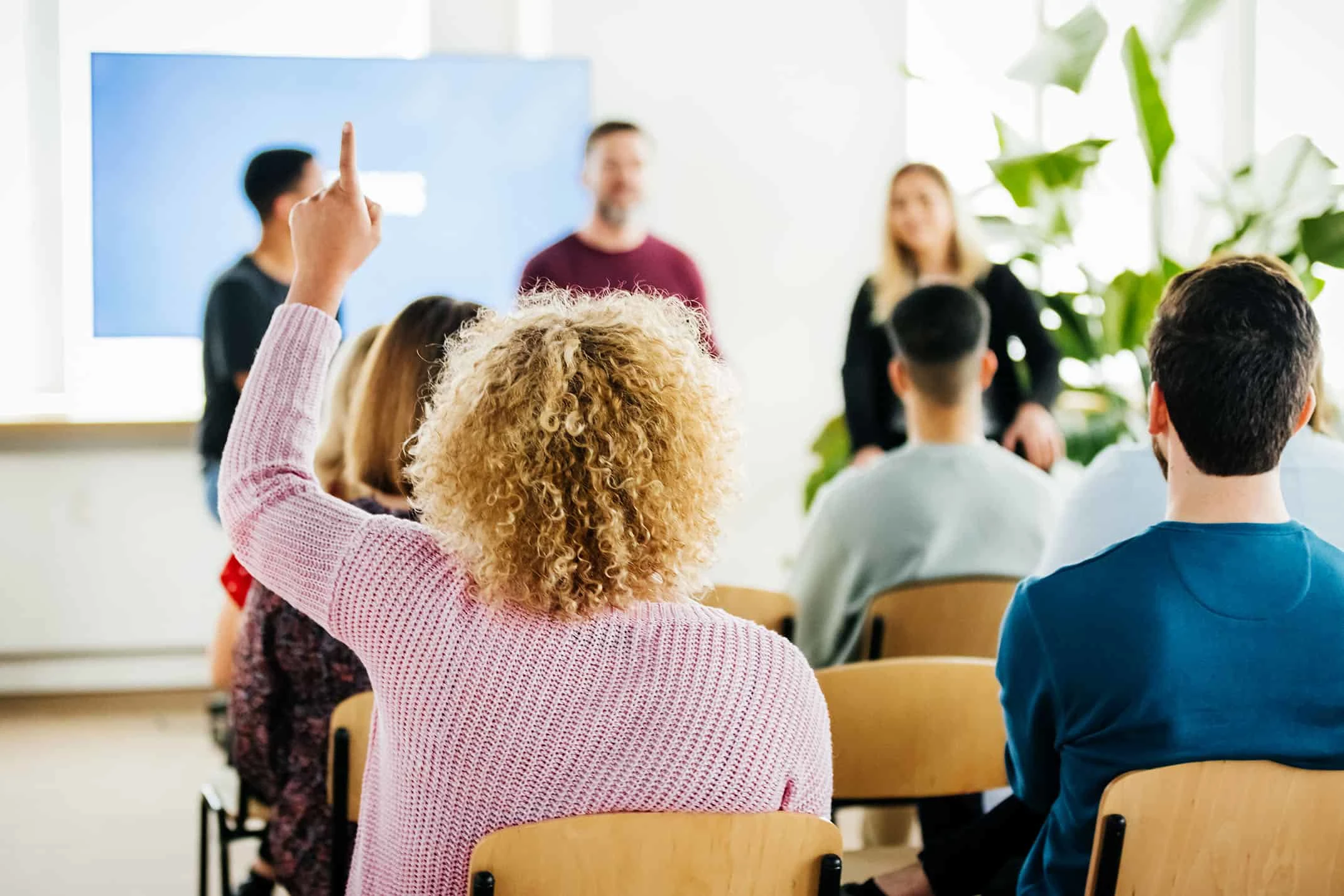 Woman raising hand during presentation