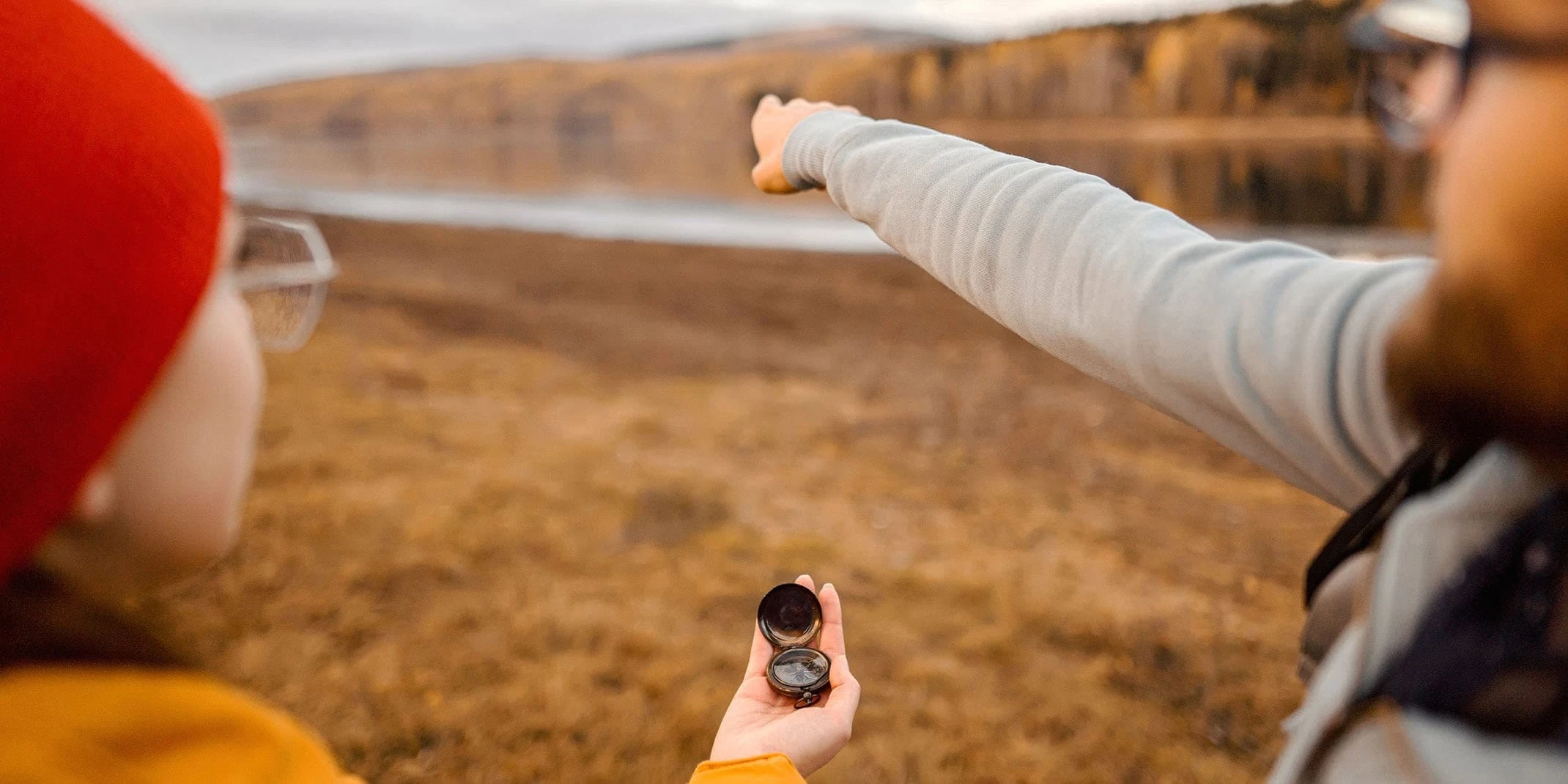 Hikers using a compass and pointing in the distance