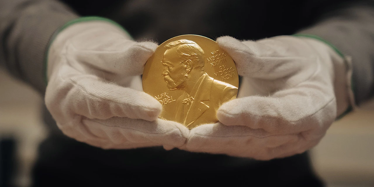 Nobel Prize medal held by gloved hands. © Nobel Prize Outreach. Photo: Clément Morin