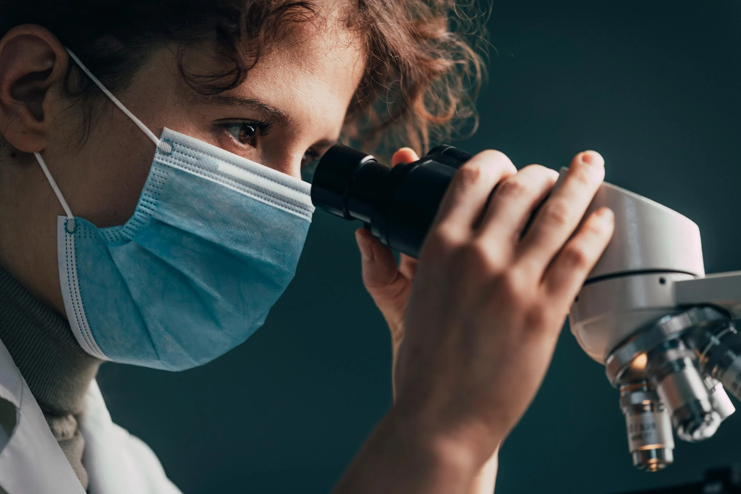 Close Up of a Medical Researcher Looking through a Microscope