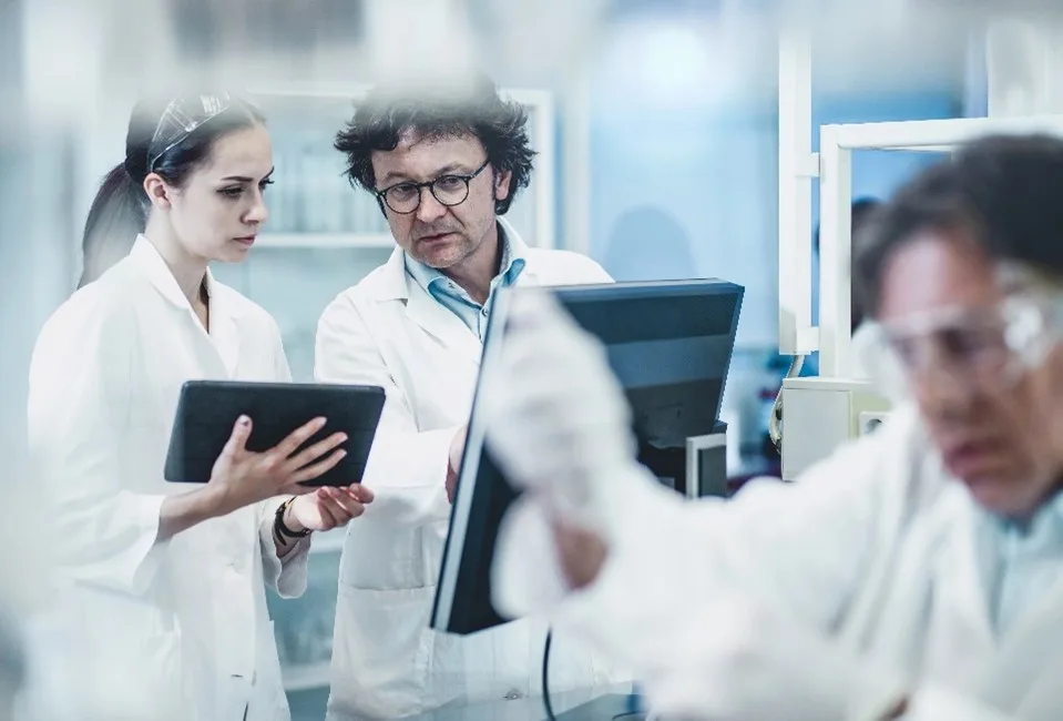 Personas trabajando en una computadora en un laboratorio