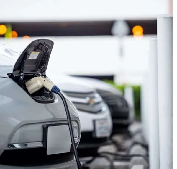 A grey electric vehicle is plugged in and charging.