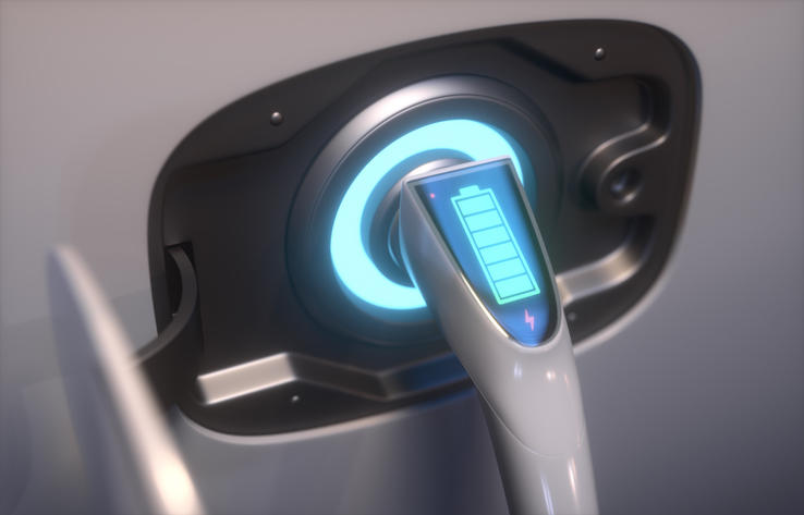 Close-up of an electric vehicle charging port with a glowing blue battery indicator on the charging plug.
