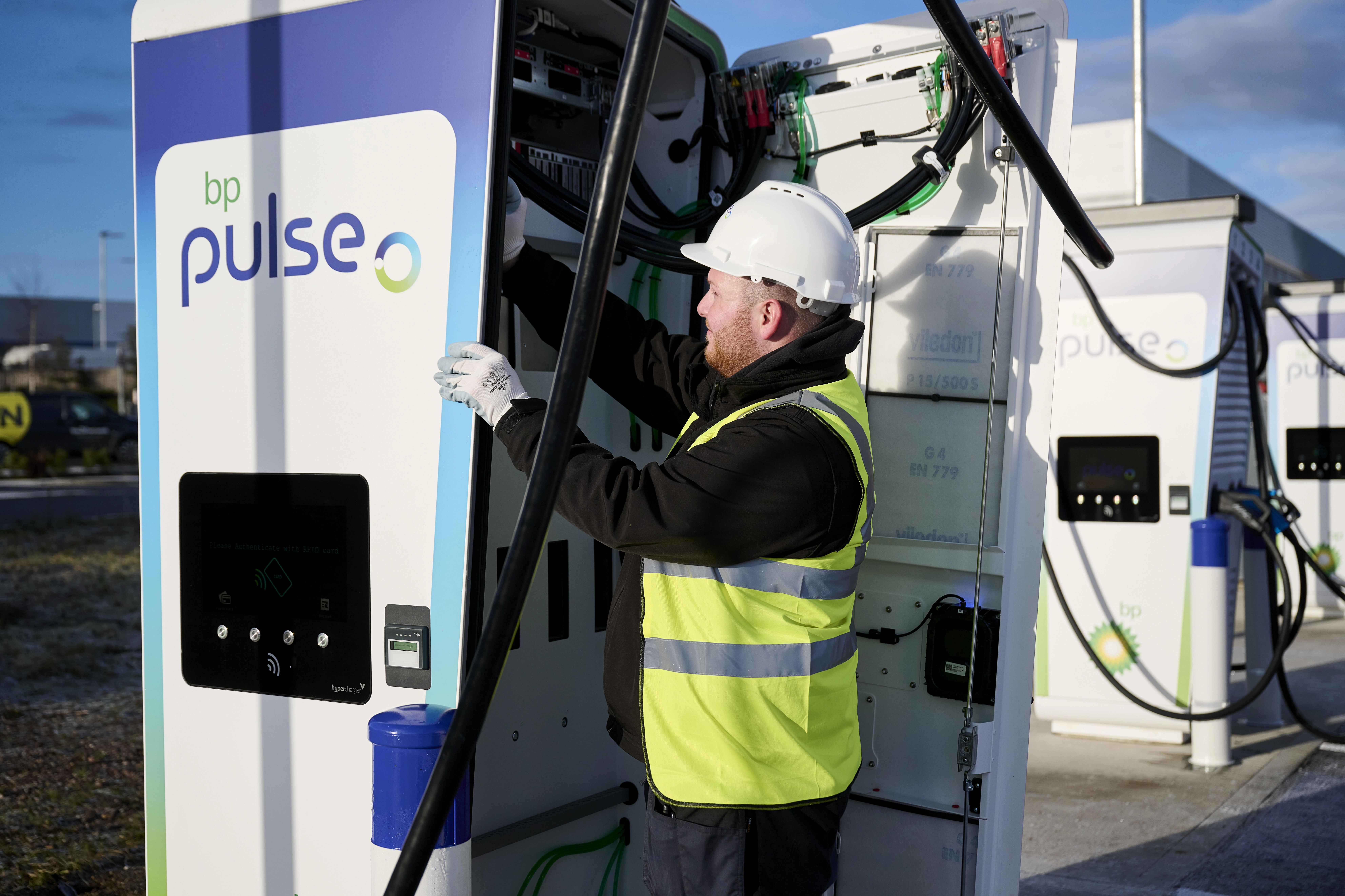 A bp pulse engineer is activating a bp pulse ev charger at a new charging site.