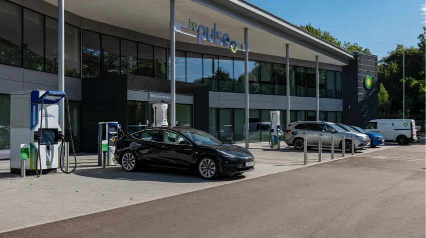 A row of electric vehicles plugged into various bp pulse chargers, located outside the bp pulse head office
