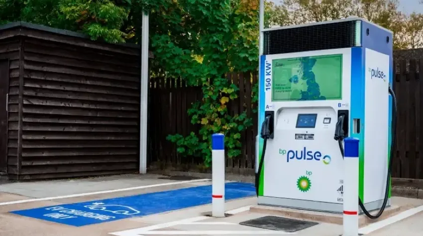A bp pulse 150kw charger next to a charging bay.