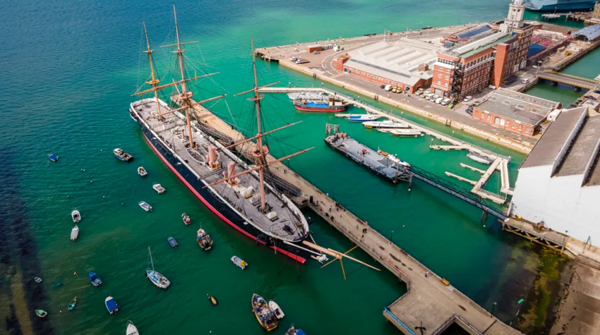A large ship is docked in Portsmouth marina.