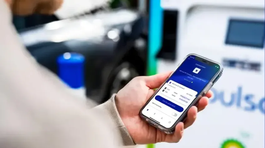 A man viewing a mobile app that displays information of an EV charging station.