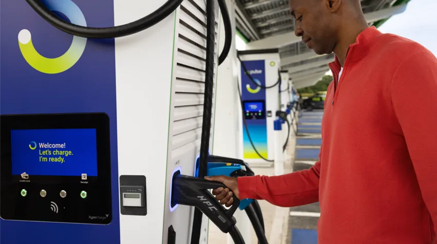 A man holding a charger at a bp pulse charging station.