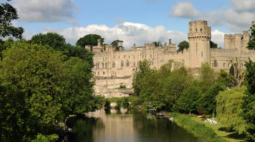 A scenic view of a castle and a moat on a sunny day.