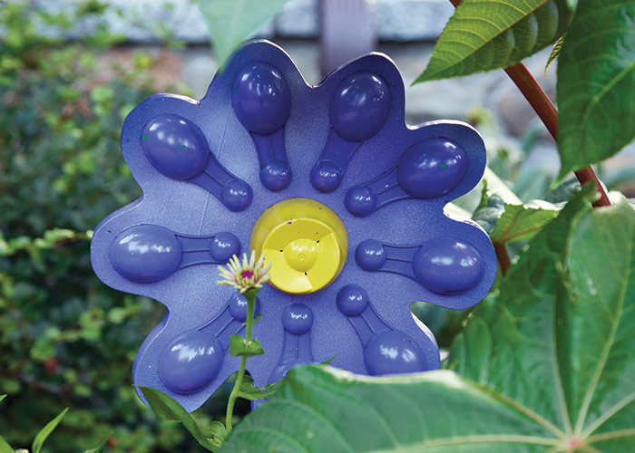 fertilizer scoop garden ornament by Candy Gagnon: Candy makes colorful flower garden ornaments from extra household items, such as fertilizer scoops, clothespins, hair dryer diffusers and more.