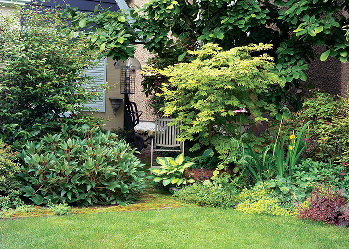 Koelink garden border with chair: This shady nook with a very narrow passage to the backyard might have ended up as a useless space. But it’s the perfect spot for a quiet retreat (or to hide a few extra garden tools).