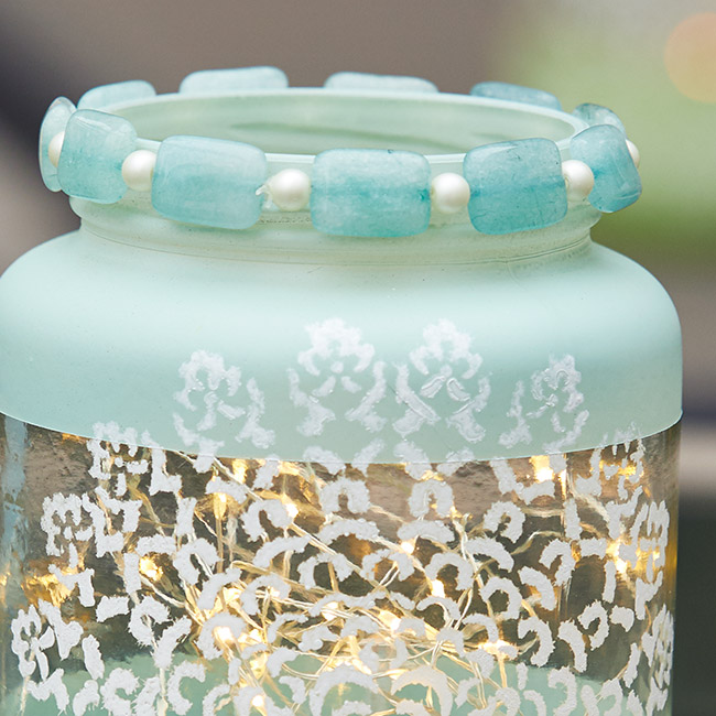 diy-jar-lantern-embellish-rim-alt: Stringing beads with clear stretch cord creates a snug fit around the rim.