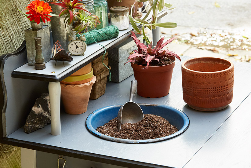 DIY-potting-bench-bowl-with-soil: This enamelware bowl is a handy addition to your potting bench perfect for holding potting mix or catching debris when repotting.