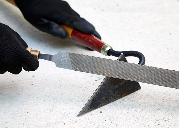 用锉刀打磨花园锄头:用锉刀打磨锄头时戴上手套是个好主意，这样你就不会不小心割伤自己。