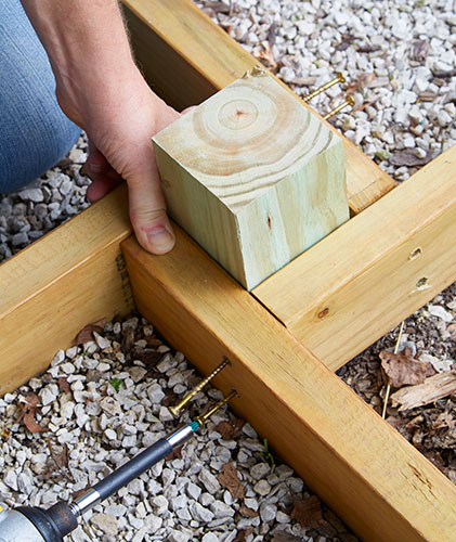 how-to-make-DIY-privacy-panels-build-the-base-Tall:A scrap piece of 4×4 keeps the angles sharp as the base goes together.