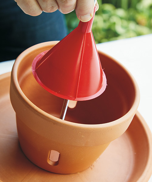 how-to-make-terra-cotta-birdfeeder-funnel-bonus-tip: Adding a funnel helps direct bird seed to the orchid pot holes.