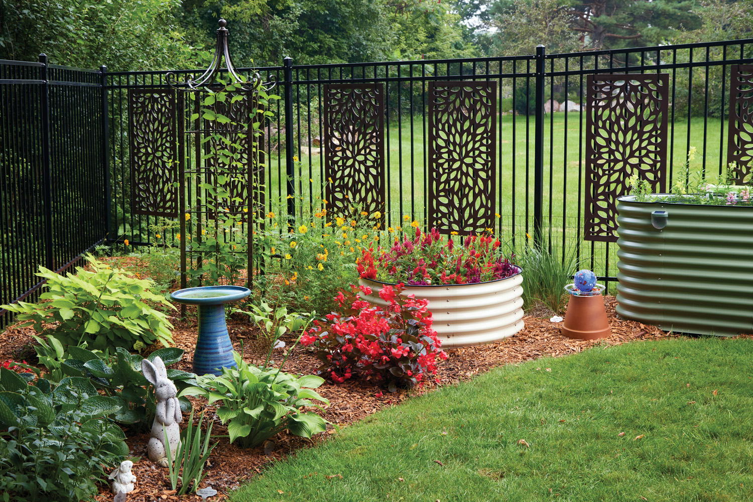 GG185 RGA Raised garden beds in backyard: Raised beds and extra fencing keep rabbits out. A layer of low fencing helps prevent rabbits from squeezing beneath the 6-foot-tall deer fence.