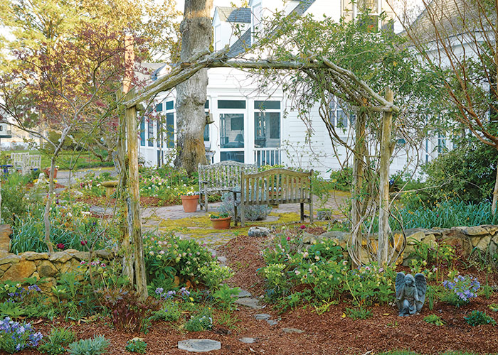 Cam Williams back patio and Arbor:  Call attention to a patio with a big arbor that beckons visitors to come on in and take a seat. Surrounding the base with plants and a low wall connects it to the garden.