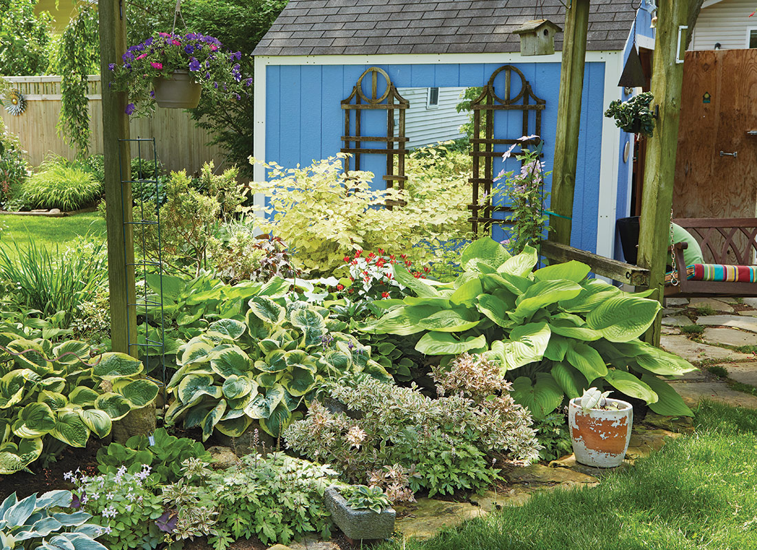 GG182 COMBOS hostas-and-weigela-lead-tall: This interesting shade garden bed is anchored by large-leaved hostas and stunning variegated foliage from My Monet weigela. Garden Design by Karen Kennedy