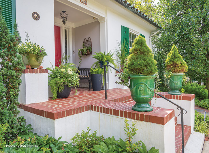entry containers: A matching pair of green urns planted with dwarf Alberta spruces add curb appeal to Anne's front entrance.