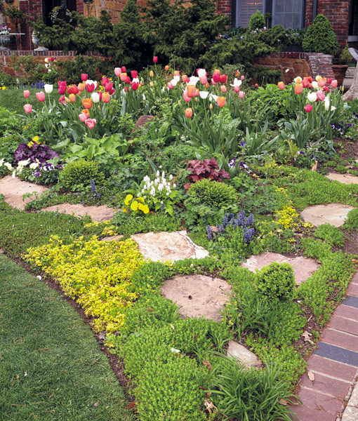 Garden bed with brick edging:  Along with brick edging, tucked-in stones play a big part in creating this garden’s classic, romantic style. 