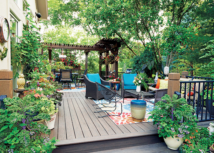 Bonnie Duma deck and patio: The two pergolas at the deck’s edge are just wide enough to support vines and hanging baskets. The trees surrounding the deck offer plenty of shade and privacy. 