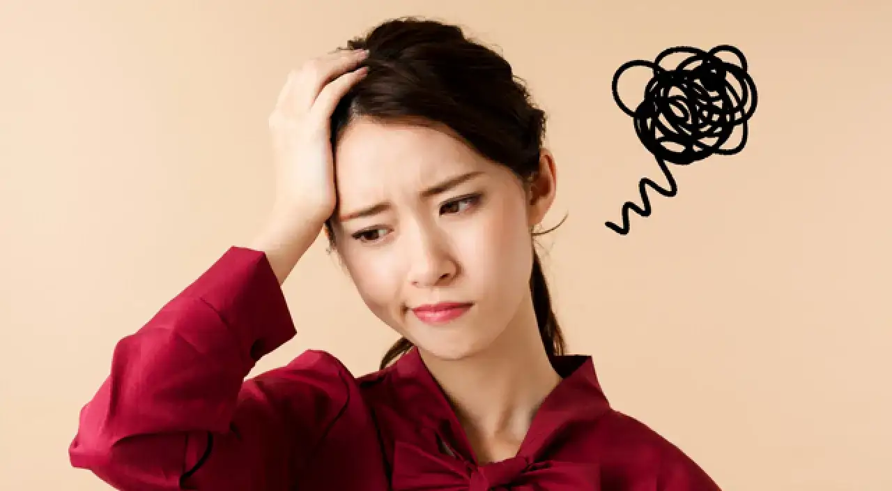 素材_頭を抑えて悩んでいる女性
