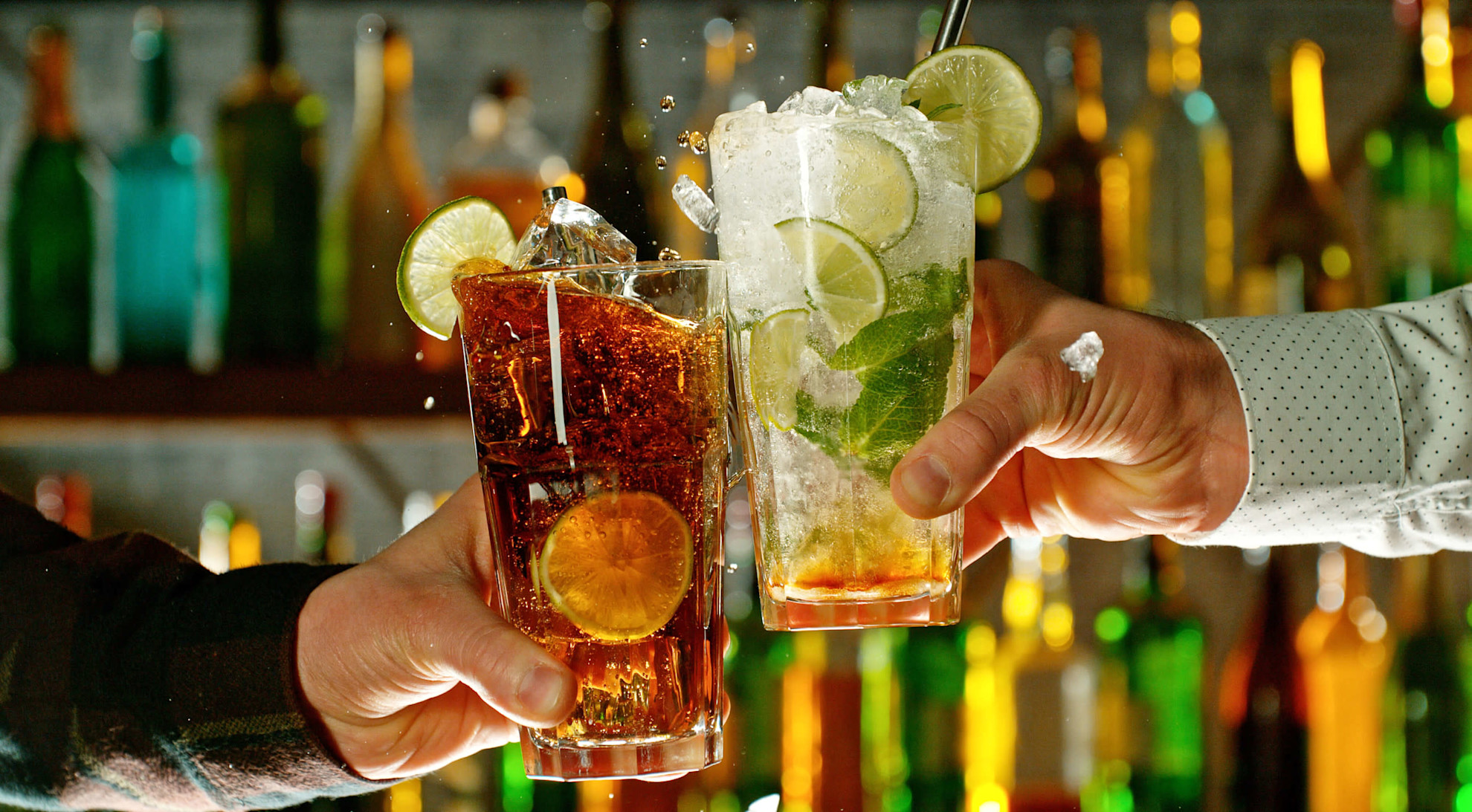 Close-up view of a two glasses of cocktails in hands
