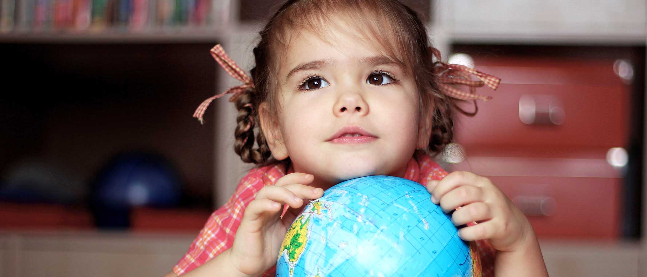 nina sosteniendo globo de la tierra