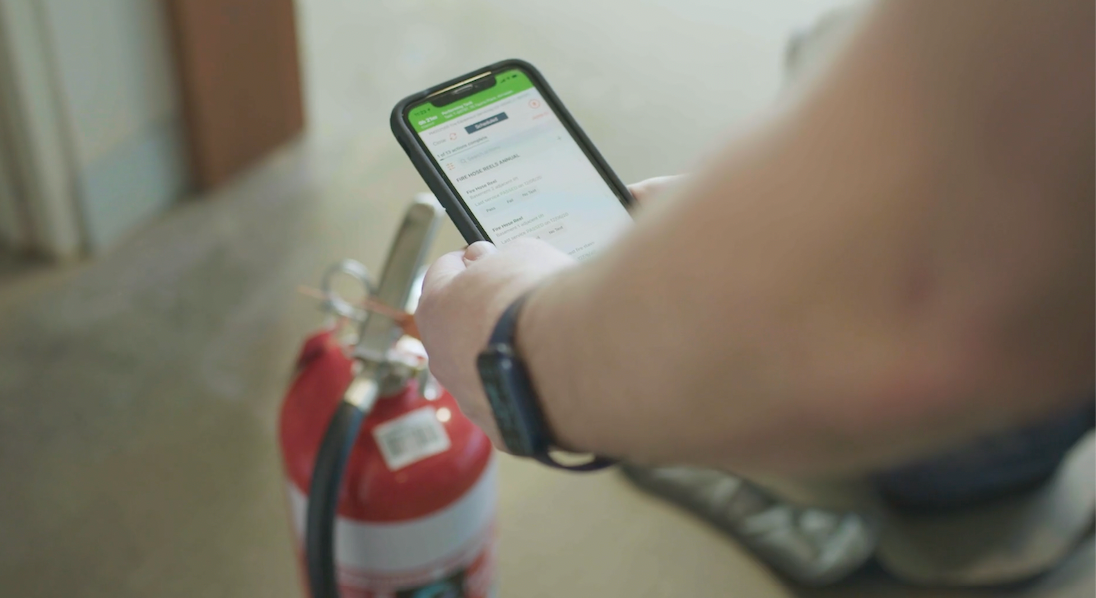 hands holding smartphone with uptick app near fire extinguisher thumbnail