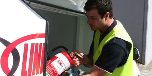 man placing fire extinguisher into linkfire hatch thumbnail