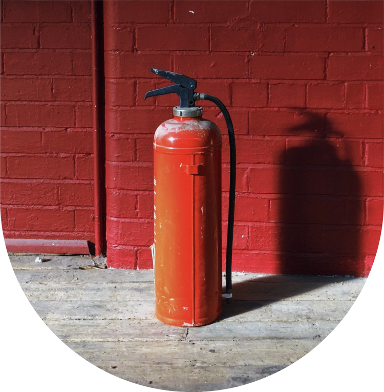 Red fire extinguisher against red brick wall