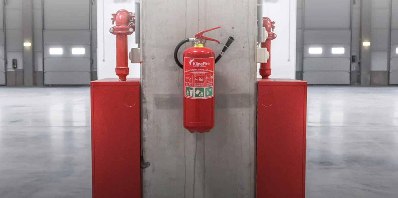 Red fire extinguisher against cement pillar