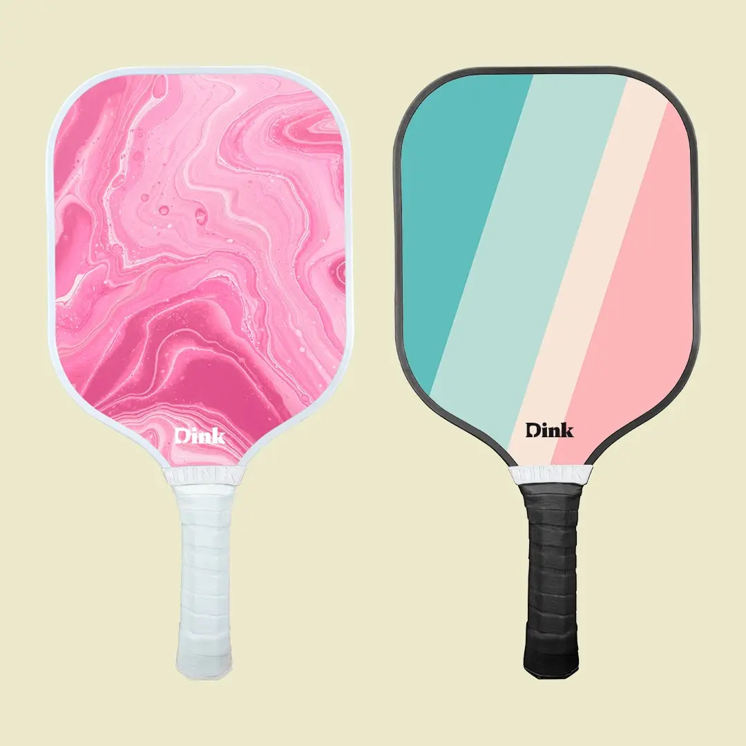 A custom set of 2 pickleball paddles one pink marbel with a white edge and other in blue and pink shades with a black edge