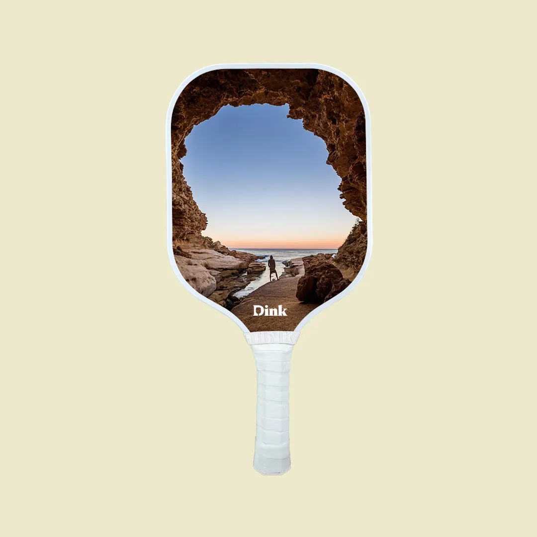 a custom pickleball paddle with a man standing on the mountain