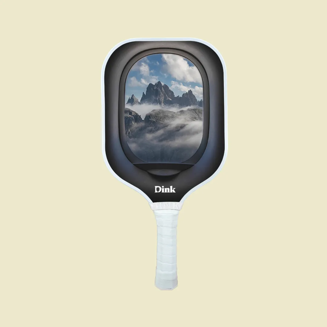 A custom pickleball paddle from Dink with a view from the plane window