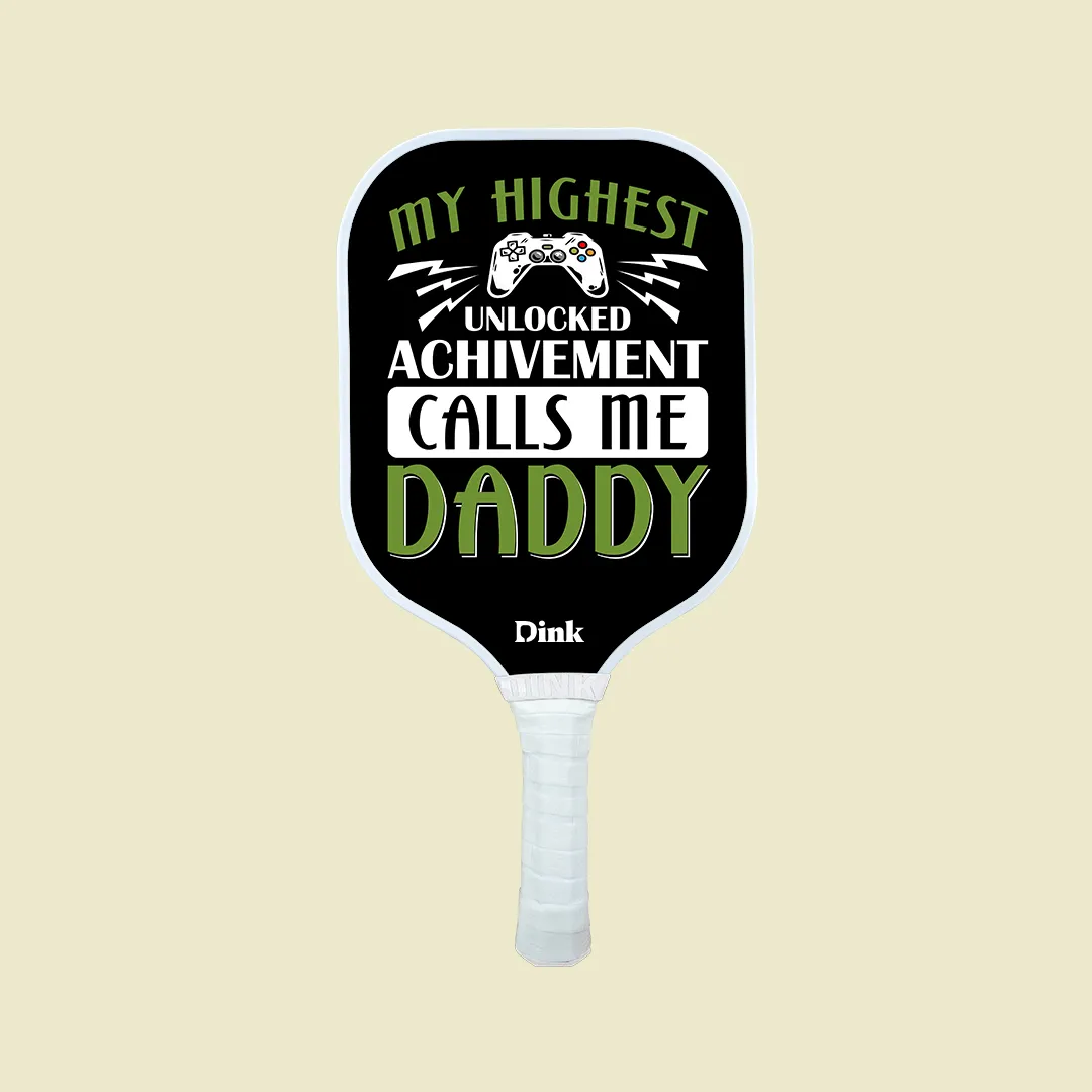 a custom pickleball paddle from Dink with words MY HIGHEST UNLOCKED ACHIEVEMENT CALLS ME DADDY