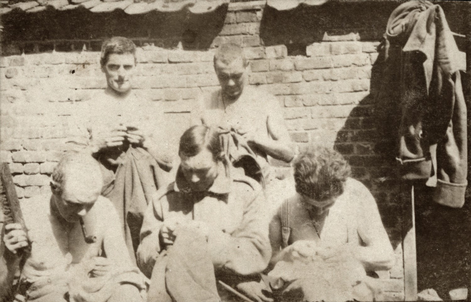 Soldiers mending clothes (or looking for lice).