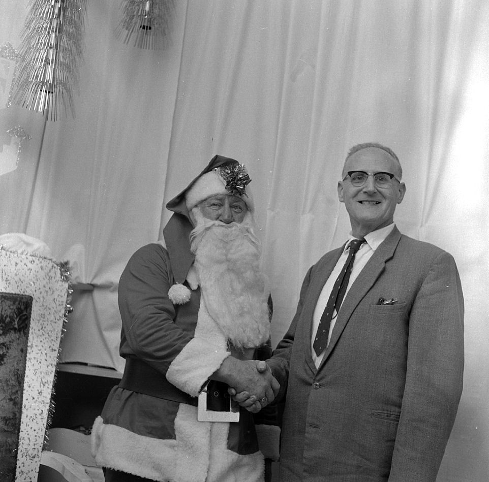 Father Christmas shaking hands with a man in a suit.