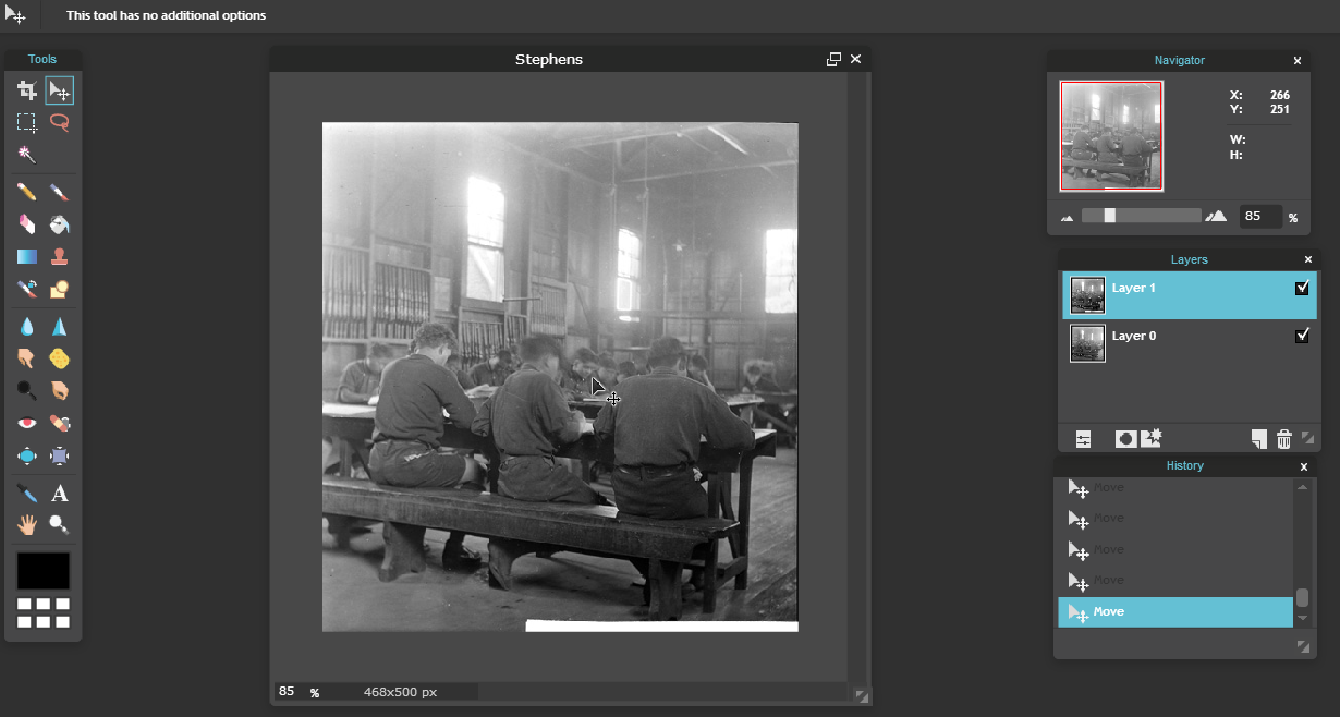 Screenshot of a photo of three boys sitting at a table in a classroom in a photo editing program
