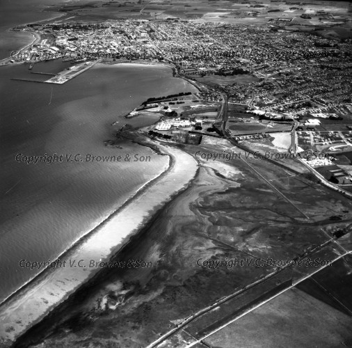 Black and white aerial photograph of a coastal town.