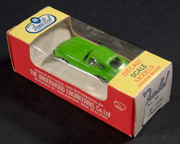 A green metal toy car in a box.