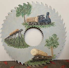 Large circular steel sawmill saw blade, hand painted with a train on tracks and carriages loaded with lumber.
